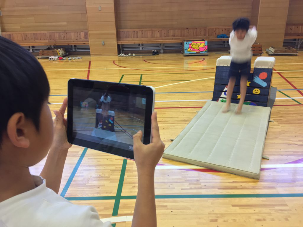 跳び箱運動のフォームを確認するため、動画撮影する児童